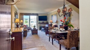 A well-lit living room with a dining area, a fireplace, and a chandelier. - Northcoast Village Beautiful Penthouse w/ large rooftop deck and VIEWS! (Oceanside)