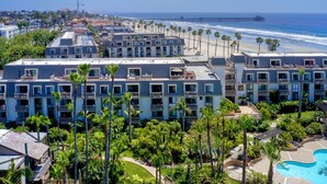 A hotel with multiple floors, a swimming pool, and a beach view. - Northcoast Village Beautiful Penthouse w/ large rooftop deck and VIEWS! (Oceanside)