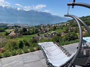A chair with a view of a lake and mountains in the background. - Modern flat with panoramic views in Jongny near Montreux (Jongny)
