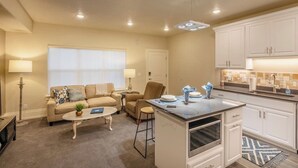 A compact living space with a kitchenette, a sofa, a coffee table, and a dining area. - Luxury Living in Downtown Provo Unit 2 (Provo)