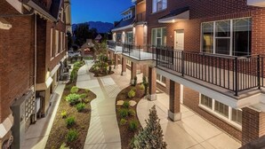 A multi-story residential building with a central courtyard, balconies, and a brick facade. - Luxury Living in Downtown Provo Unit 2 (Provo)