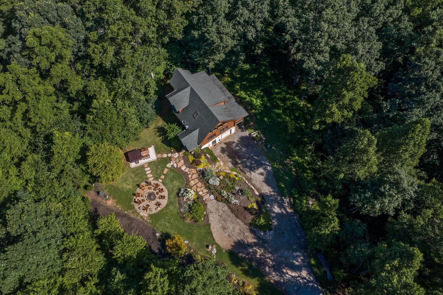 Vista aérea de una casa rodeada de un bosque denso.