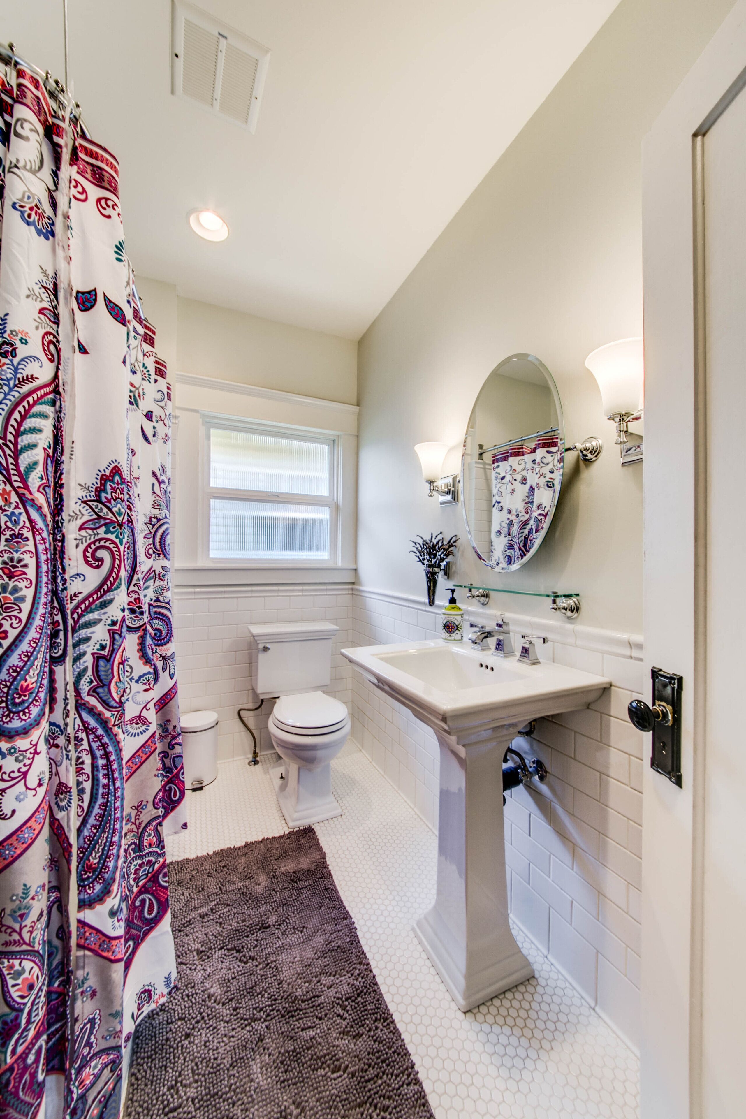 A bathroom with a toilet, sink, and shower curtain.
