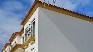 A row of modern, white buildings with balconies, a well-maintained lawn, and a clear sky. - Violante Apartment Beach (Foz do Arelho)
