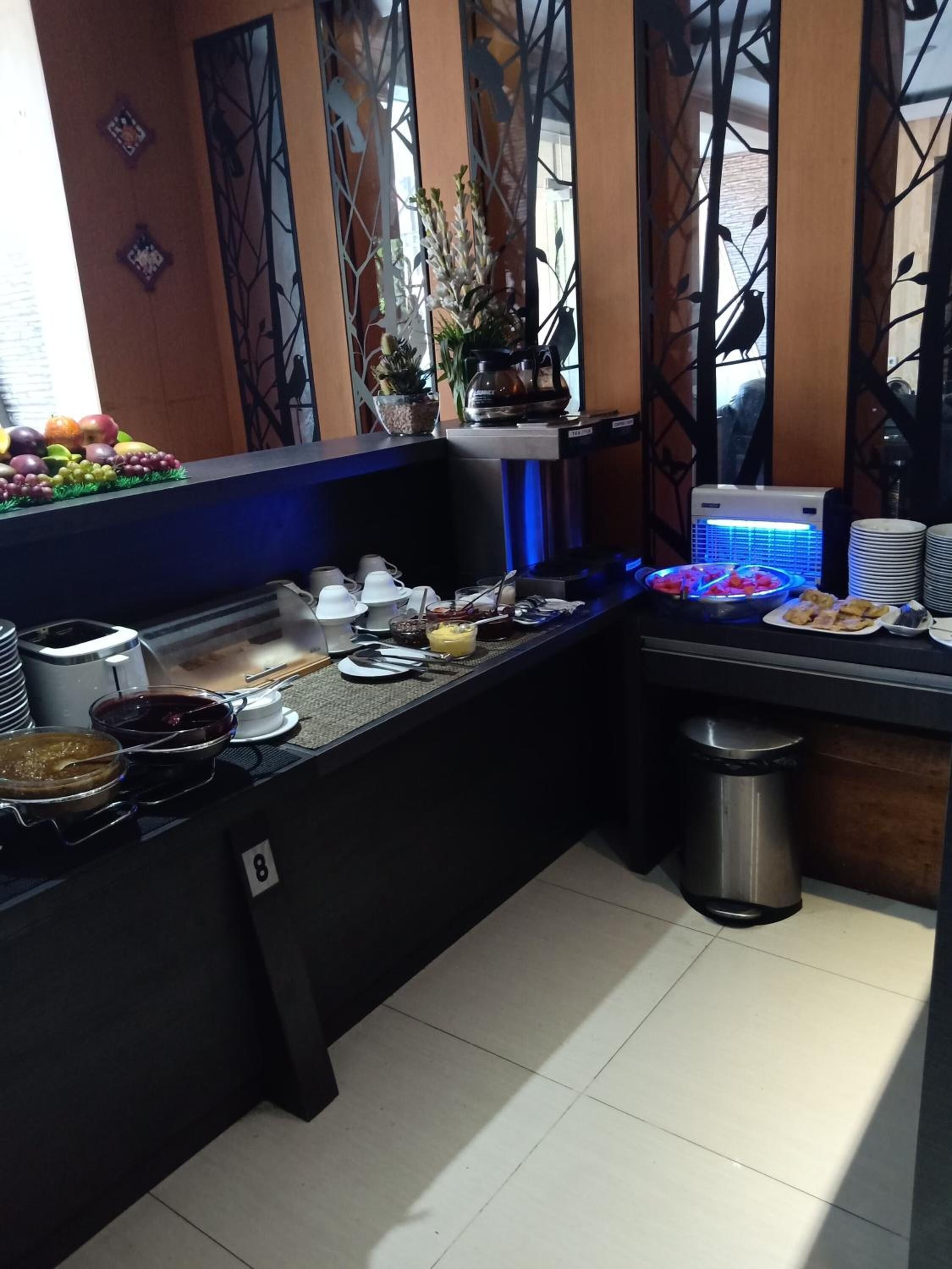 A buffet setup with various food items and utensils.