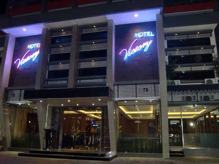 Um hotel com fachada moderna, letreiros iluminados e entrada em vidro.