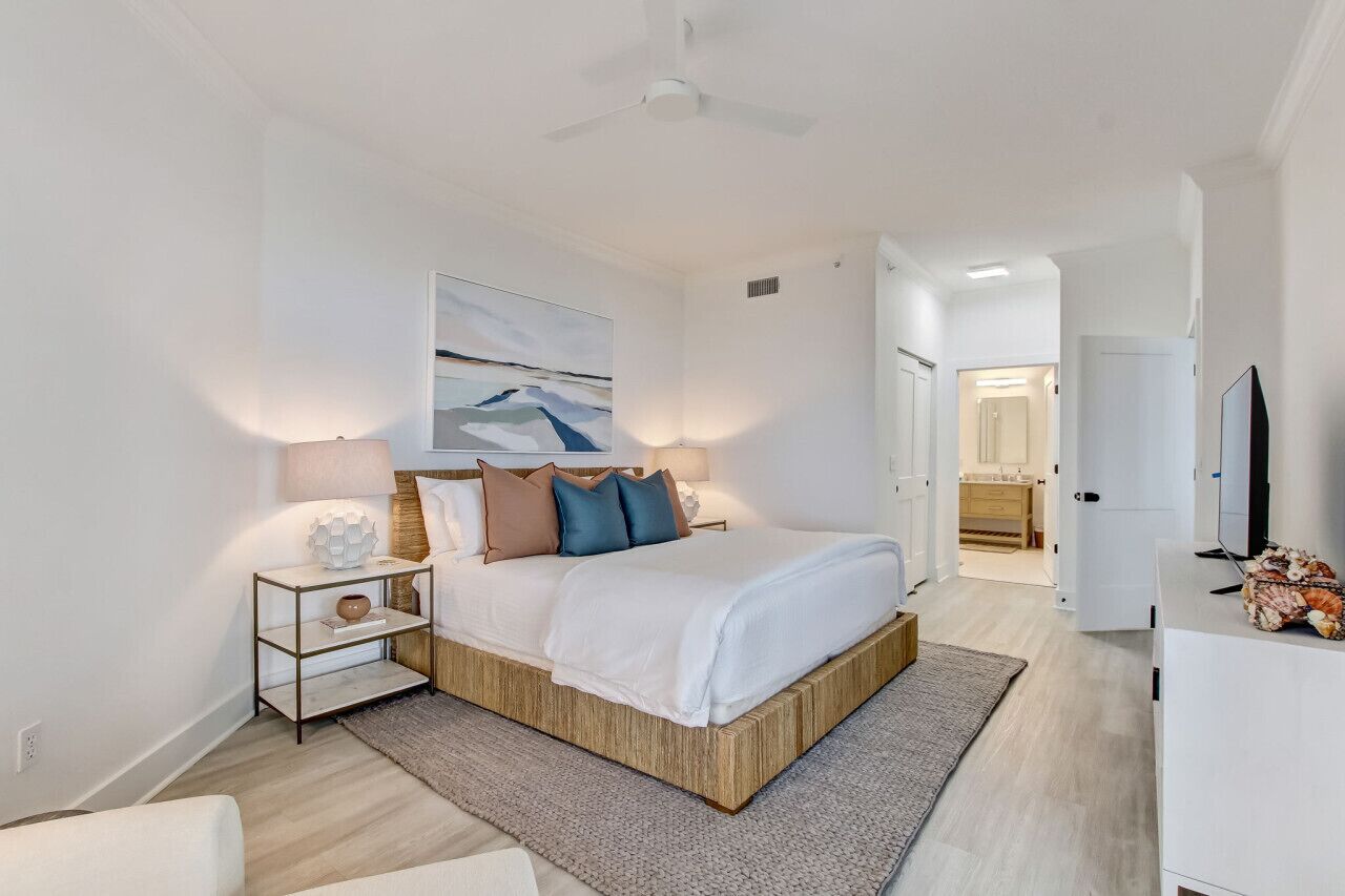 Une chambre à coucher moderne avec un cadre de lit en bois, une tête de lit blanche et un tableau au-dessus du lit.