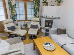 A living room with two leather recliners, a sofa, a coffee table, and a fireplace.