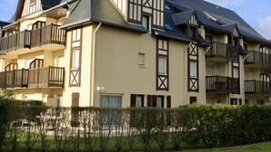 Un immeuble à plusieurs étages, de style architectural traditionnel, caractérisé par un mélange de toits à pignon et de lucarnes.