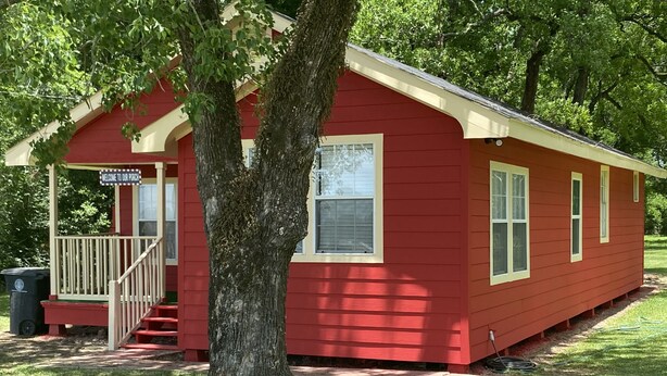 A red wooden building with a porch and a sign that reads "Welcome to our porch." - My Lil Red House.... (Baton Rouge)
