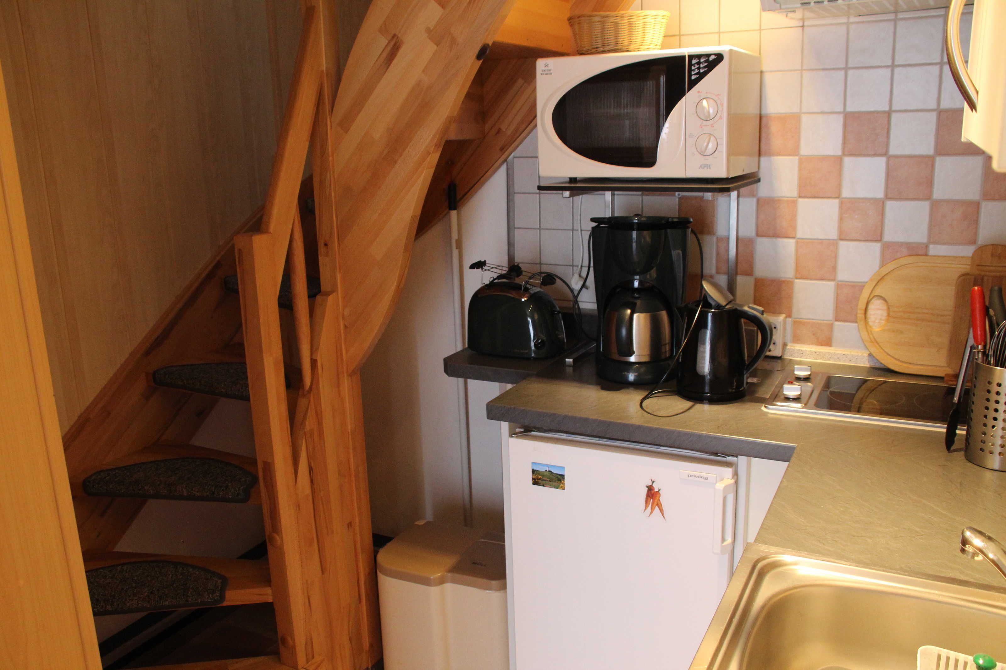 A compact kitchen with a microwave, coffee maker, and toaster.
