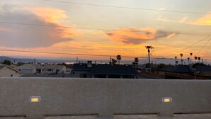 Une vue au coucher du soleil sur des immeubles résidentiels et des palmiers.