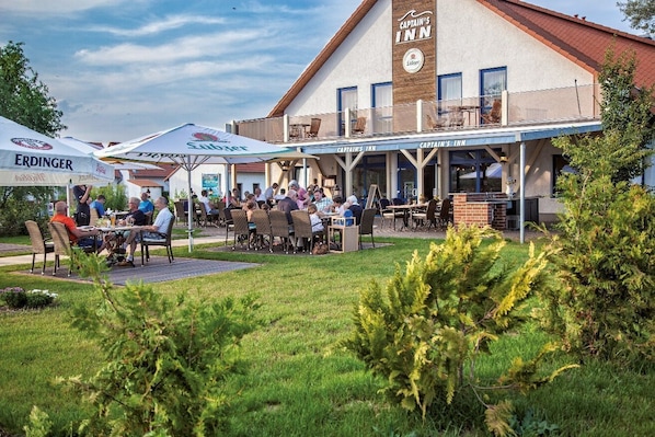 A restaurant with outdoor seating, a covered patio, and a sign for Captain's Inn.