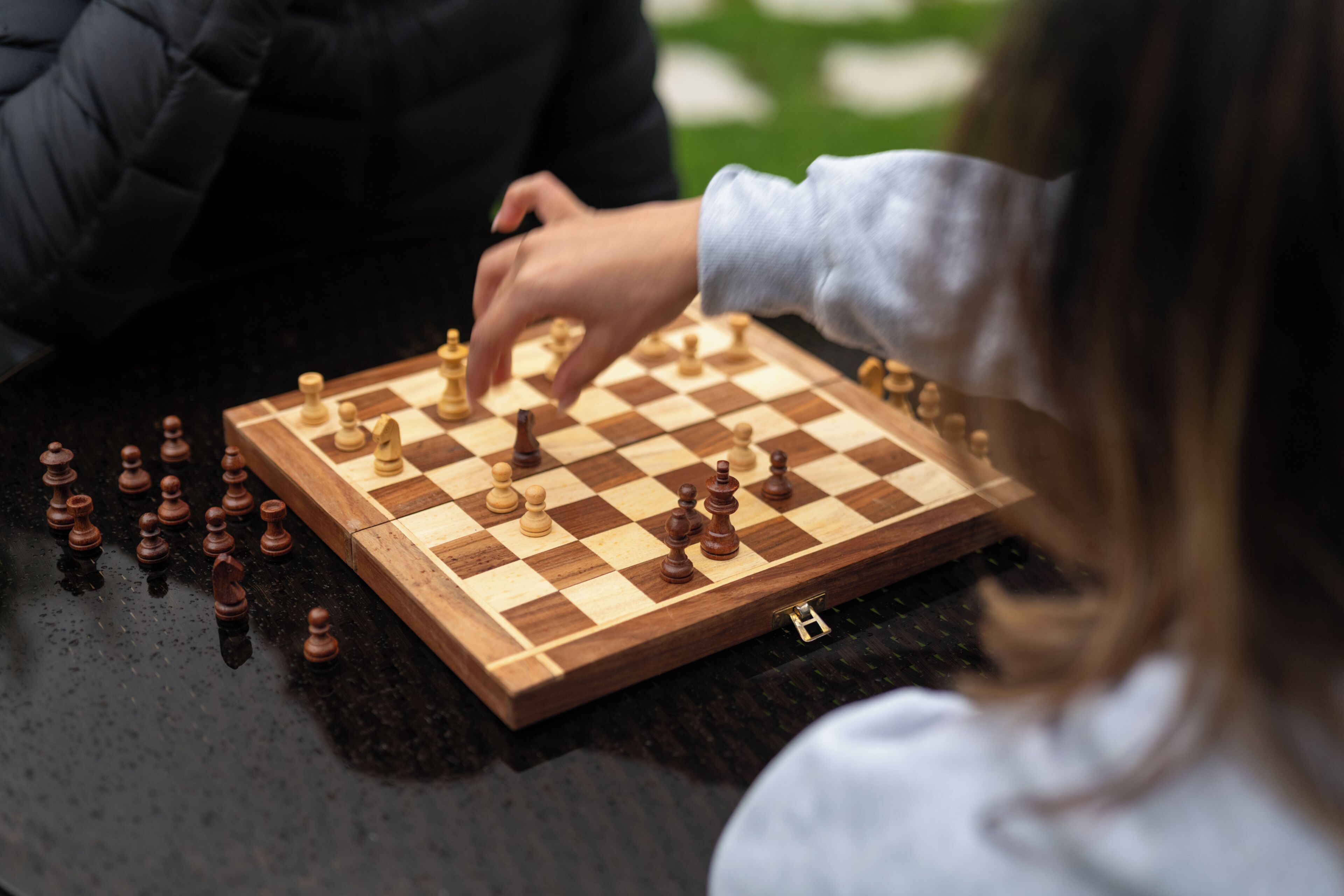 A chessboard with pieces on a table.