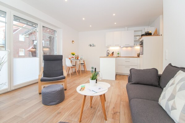 A modern apartment with a living room, dining area, and kitchen.