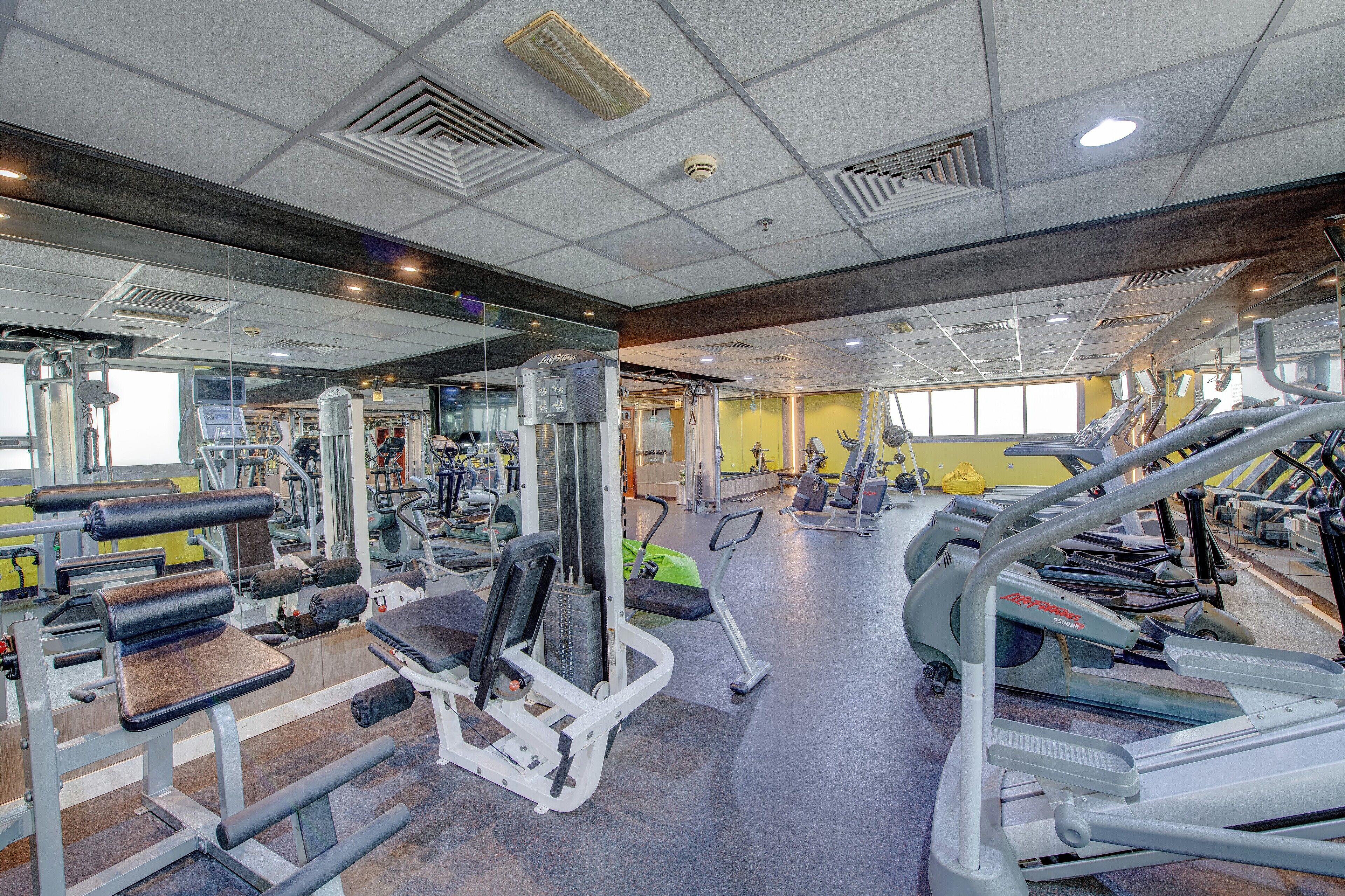 A gym with various exercise equipment, including treadmills and weight machines.