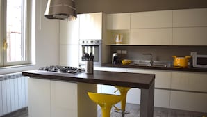 Una cocina moderna con una isla central, electrodomésticos de acero inoxidable y un ventanal que aporta luz natural.