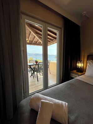 A hotel room with a bed, a nightstand, a lamp, and a view of a dining area and water outside. - Farrys Boutique Hotel & Beach Club (Bodrum)