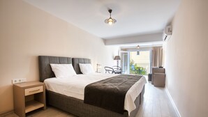 A bedroom with a bed, bedside table, and a view of the outside balcony. - Farrys Boutique Hotel & Beach Club (Bodrum)