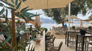 An outdoor seating area with tables and chairs, overlooking a body of water. - Farrys Boutique Hotel & Beach Club (Bodrum)