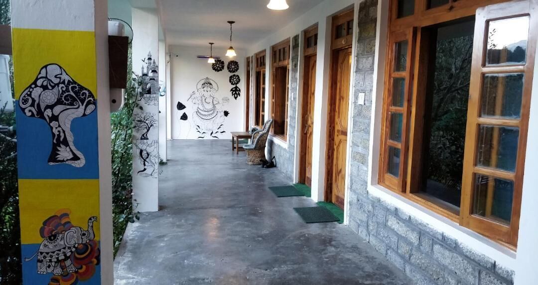 A corridor with a concrete floor, wooden doors, and a mural on the wall.
