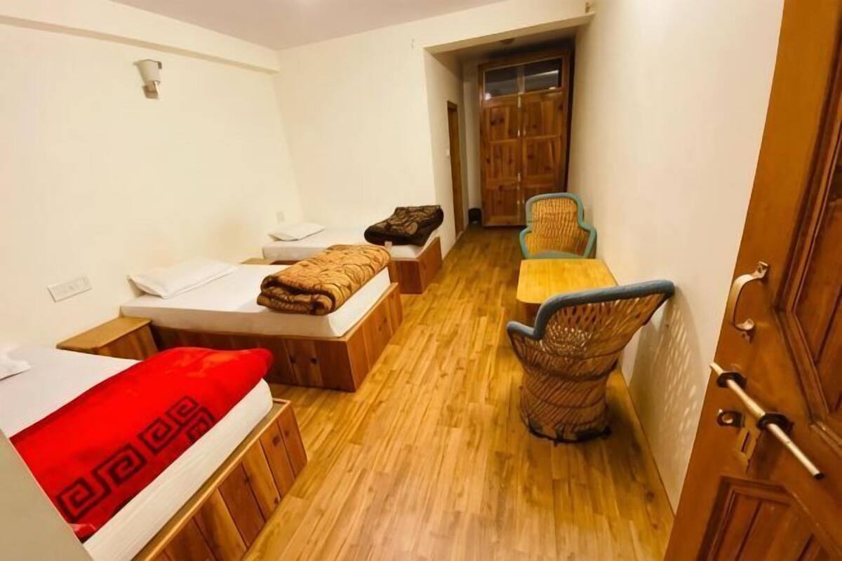 Una habitación pequeña y funcional con cama, mesa y silla.