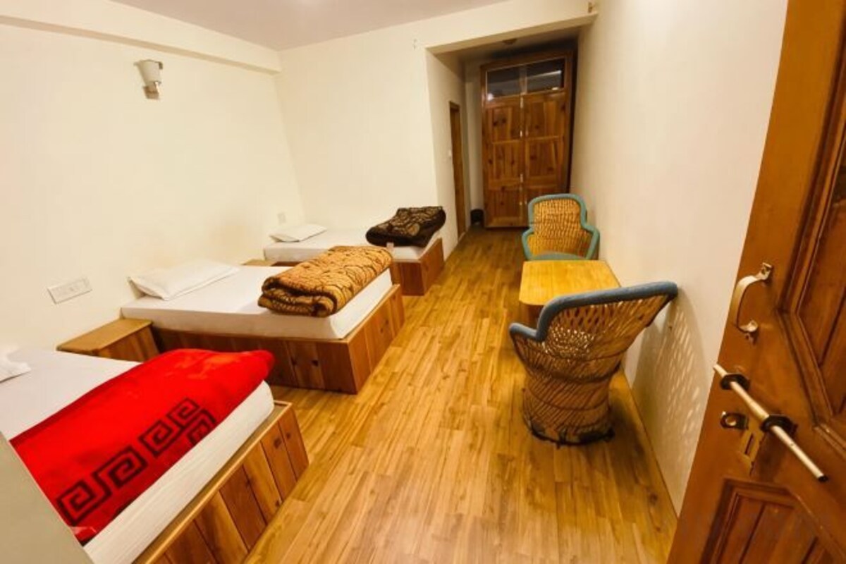A compact room with a bed, a small table, and a chair.