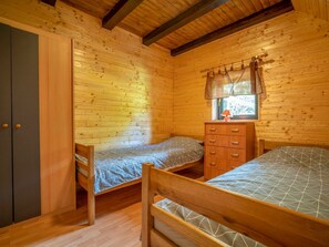 A cabin room with two bunk beds, a dresser, and a wardrobe.