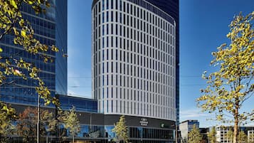 Stunning building with a curved facade and lush green surroundings.