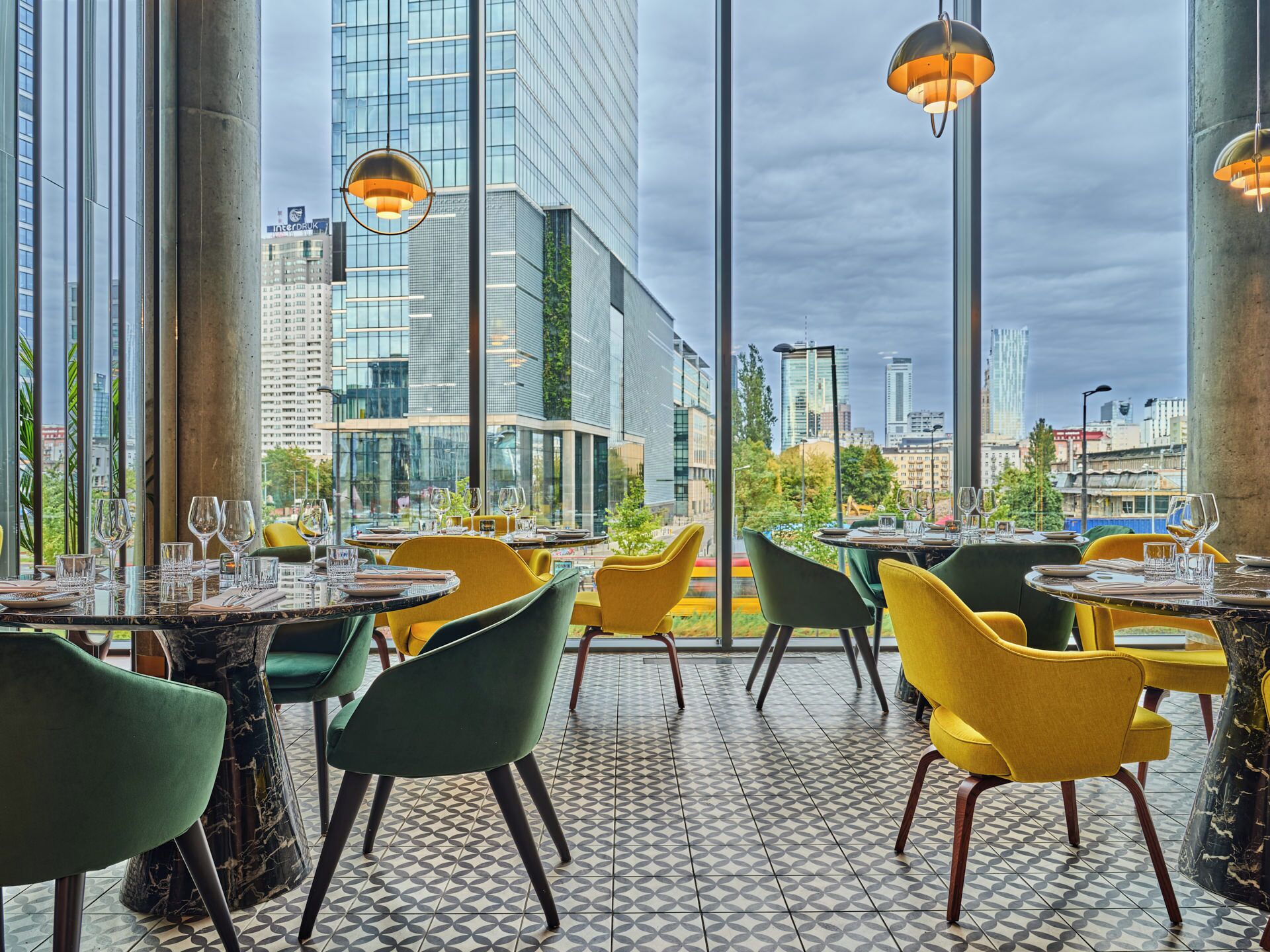 A restaurant with modern decor, large windows, and a city view.