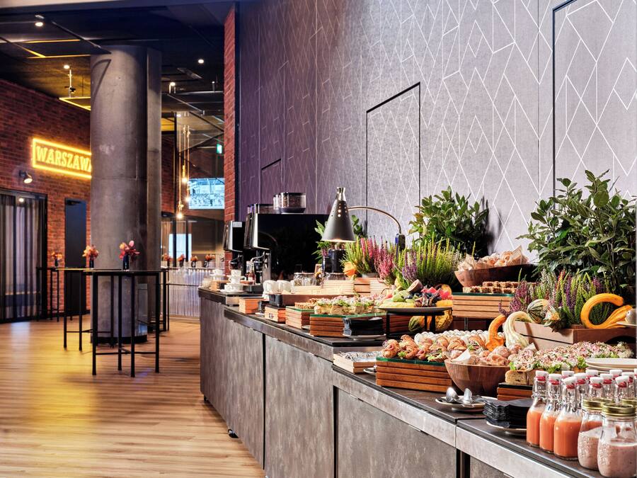 A buffet with various food items, a coffee station, and a bar area with seating.