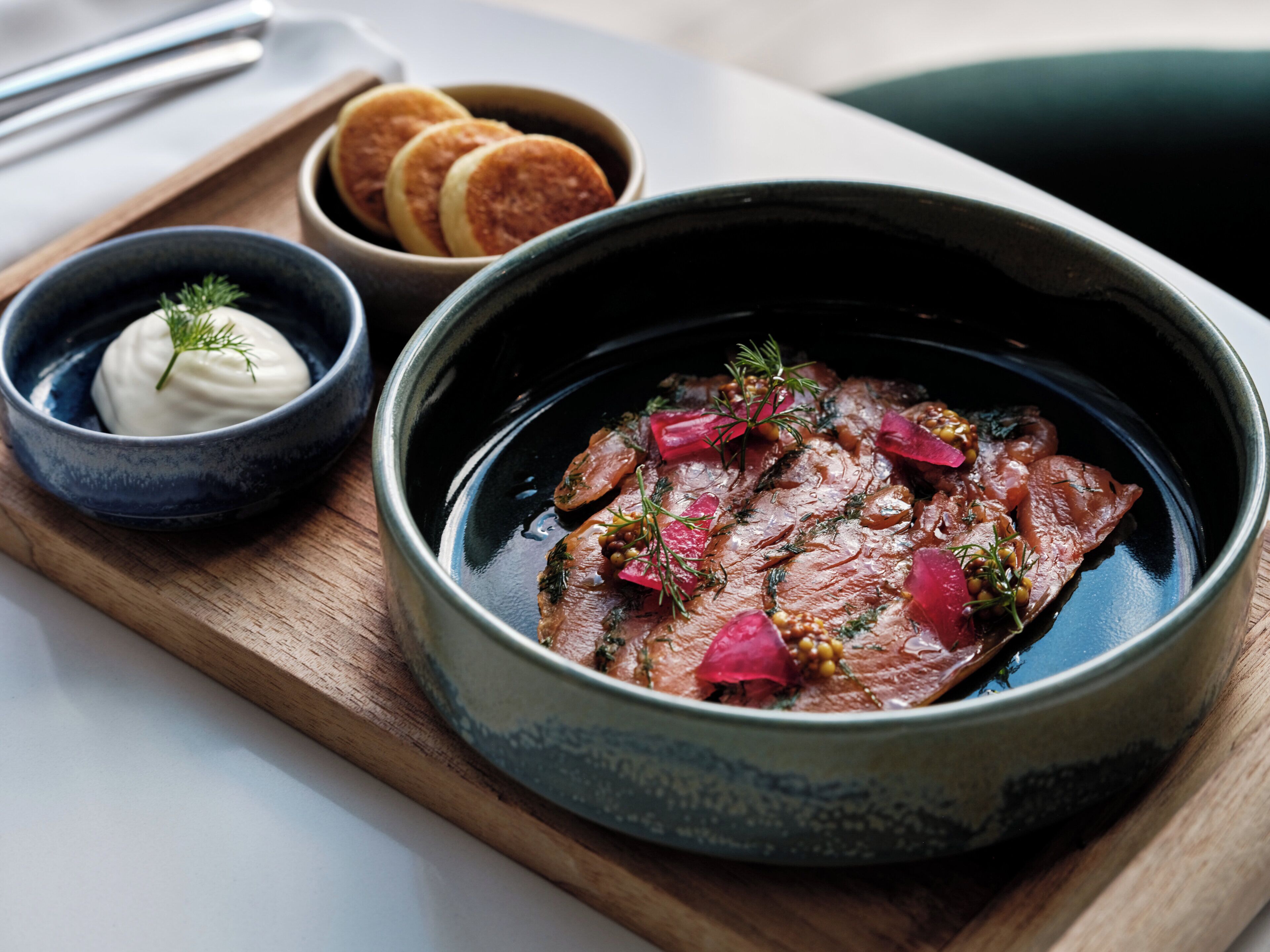 A bowl of food with a side of bread and a small bowl of sauce.
