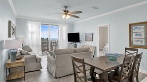 A living room with a sofa, a TV, and a dining table with chairs.