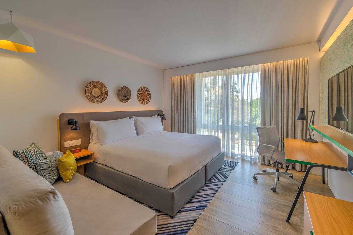 Una camera d'albergo moderna con un letto grande, una scrivania e una sedia.