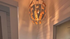 A staircase with white paneling, a wooden handrail, and a unique spherical light fixture. - Beautiful Modern A-Frame in Southern Vermont is The Place To BE! (Whitingham)