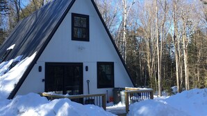 A white building with a black roof and a triangular shape, surrounded by snow and trees. - Beautiful Modern A-Frame in Southern Vermont is The Place To BE! (Whitingham)