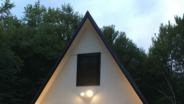 A triangular building with a balcony and red chairs. - Beautiful Modern A-Frame in Southern Vermont is The Place To BE! (Whitingham)