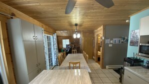 A kitchen with a central island, cabinets, and a ceiling fan.