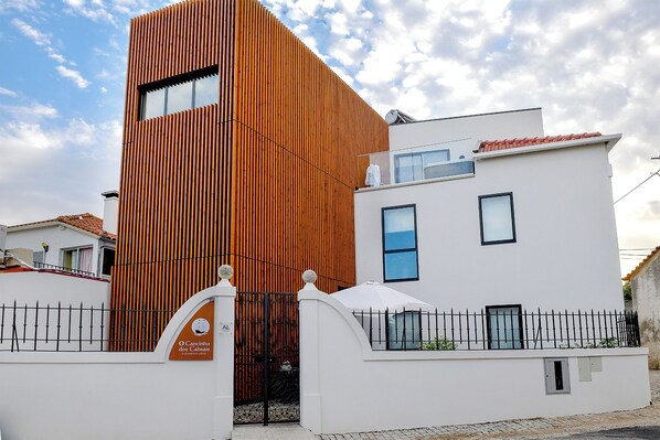 Un edificio moderno con fachada de madera y exterior blanco.