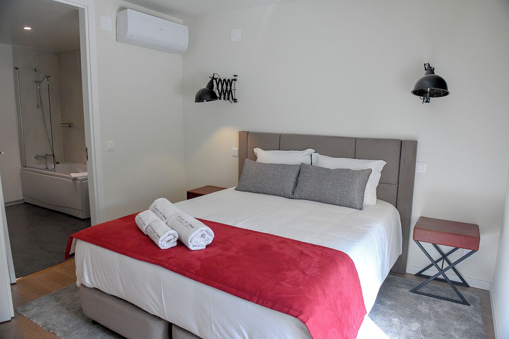 A hotel room with a bed, a shower, and a nightstand.