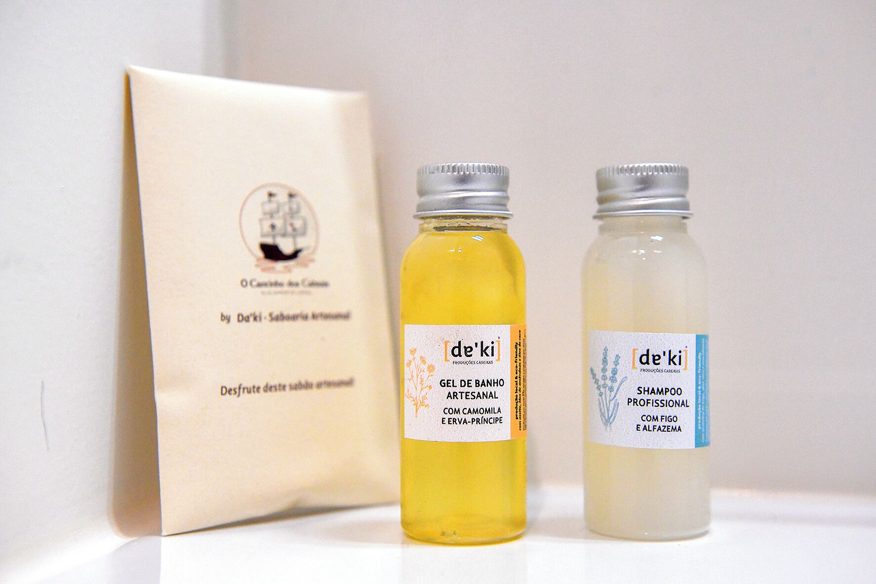 Zwei Flaschen de'ki Produkte und eine beigefarbene Packung mit Text.