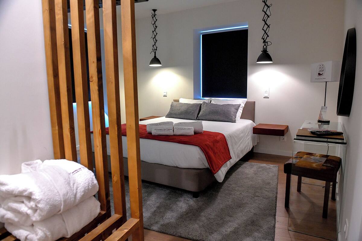 A bedroom with a bed, bedside tables, a desk, and a chair.