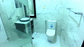 Un bagno con il water, un lavandino e una cabina doccia in vetro.
