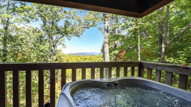 A hot tub on a wooden deck with a view of a forest and mountains. - GreatView!PoolTable,HotTub,Privacy,Fireplace (Sevierville)