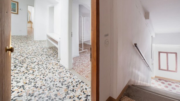 A room with a terrazzo floor, white walls, a wooden door, and a staircase. - Ca' Rosalba, Biennale next to San Marco (Venezia)