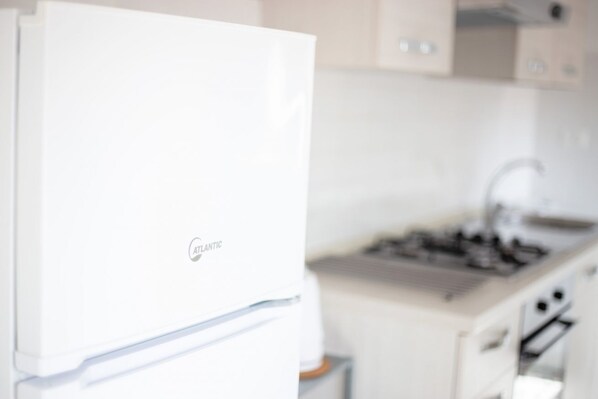 Una cocina con un refrigerador blanco, una estufa y armarios.