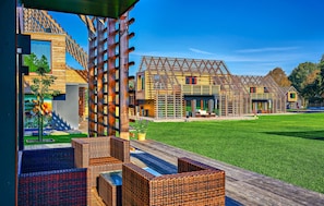 A modern house with a spacious outdoor area, including a wooden deck and outdoor furniture.
