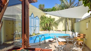 A poolside area with a pool, lounge chairs, and a table set for dining. - Awesome home in Scoglitti with private swimming pool, can be inside or outside (Scoglitti)