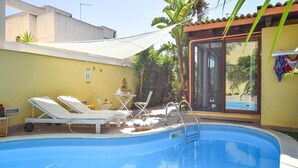 A swimming pool with lounge chairs, a table, and chairs. - Awesome home in Scoglitti with private swimming pool, can be inside or outside (Scoglitti)