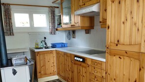 A kitchen with wooden cabinets, a sink, and a stove. - Holiday house with big garden, Resa Valley, Locarno (Brione sopra Minusio)